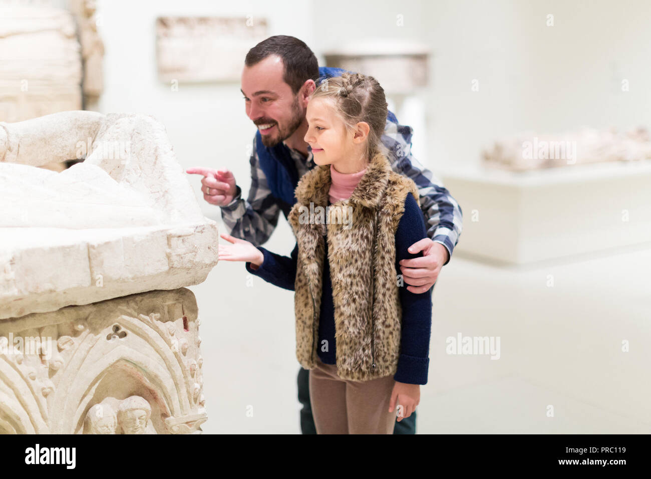 Padre Felice e piccola ragazza cercando di antichi bassorilievi in museo Foto Stock