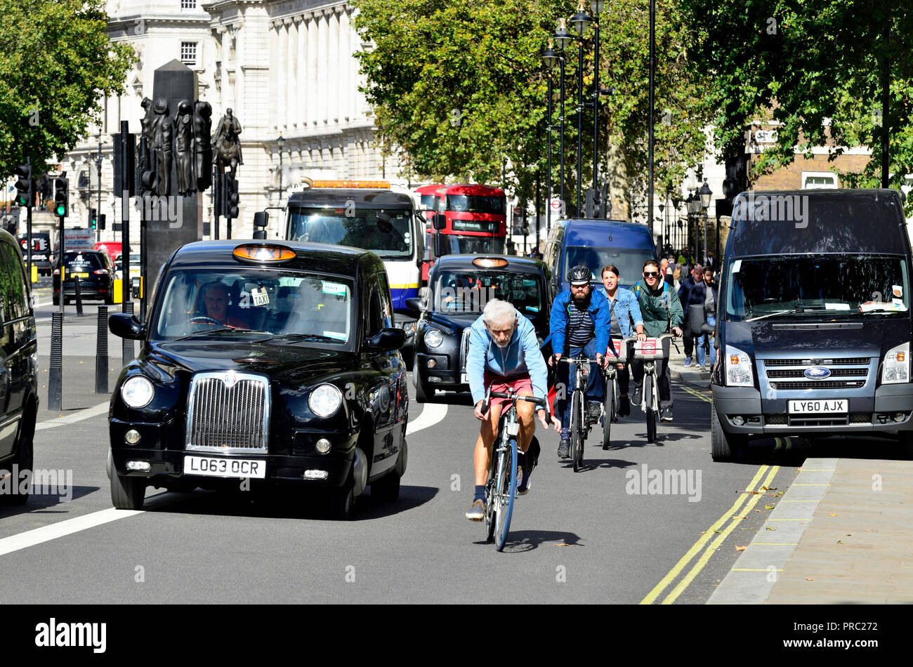 I taxi e i ciclisti in Whitehall, Londra, Inghilterra, Regno Unito. Foto Stock