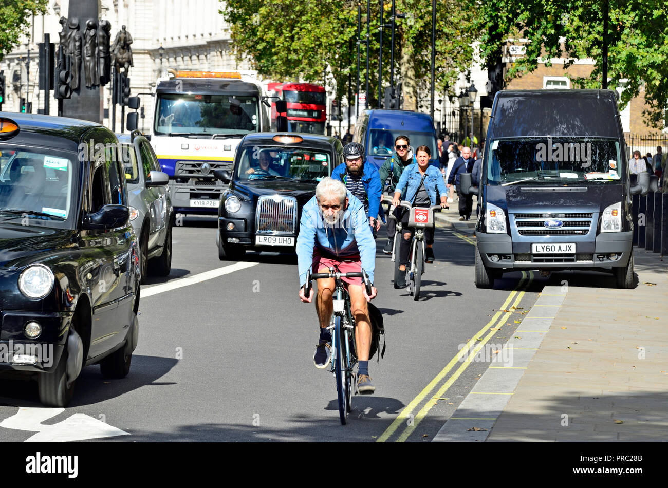 I taxi e i ciclisti in Whitehall, Londra, Inghilterra, Regno Unito. Foto Stock