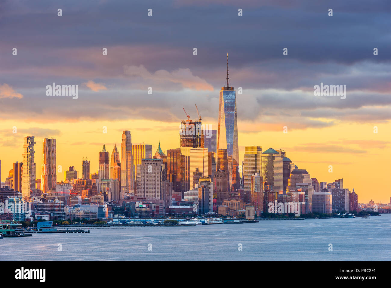 New York New York, inferiore dello Skyline di Manhattan da attraverso il Fiume Hudson all'alba. Foto Stock