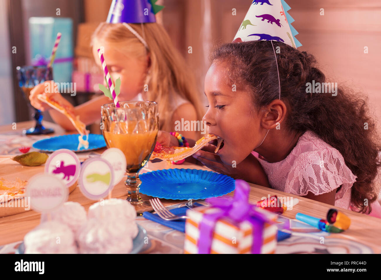 Hungry girl apre la sua bocca e mangiare pizza deliziosa Foto Stock