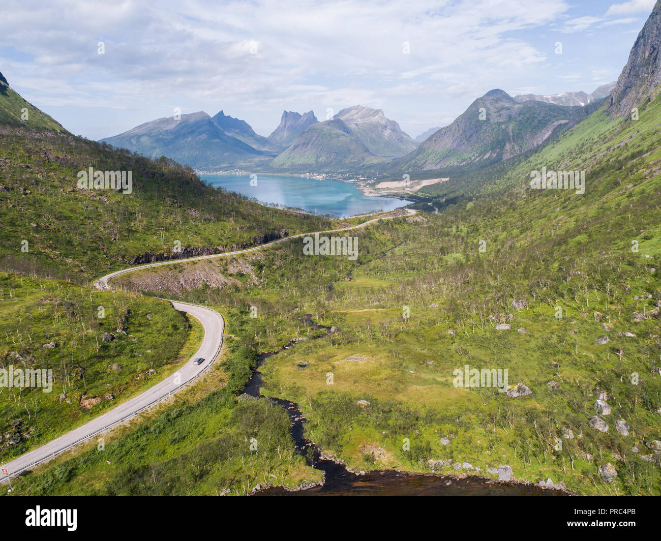 Vista aerea di una strada nel paesaggio di montagna al giorno d'estate e di sole Foto Stock