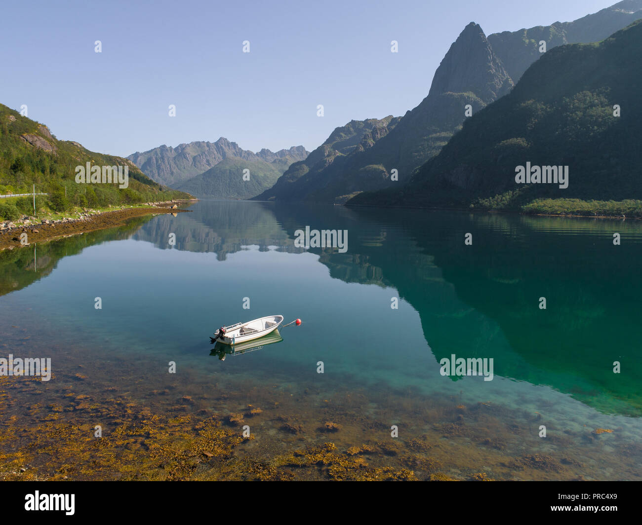 Vista aerea di una barca in un lago contro il paesaggio di montagna al giorno d'estate e di sole Foto Stock