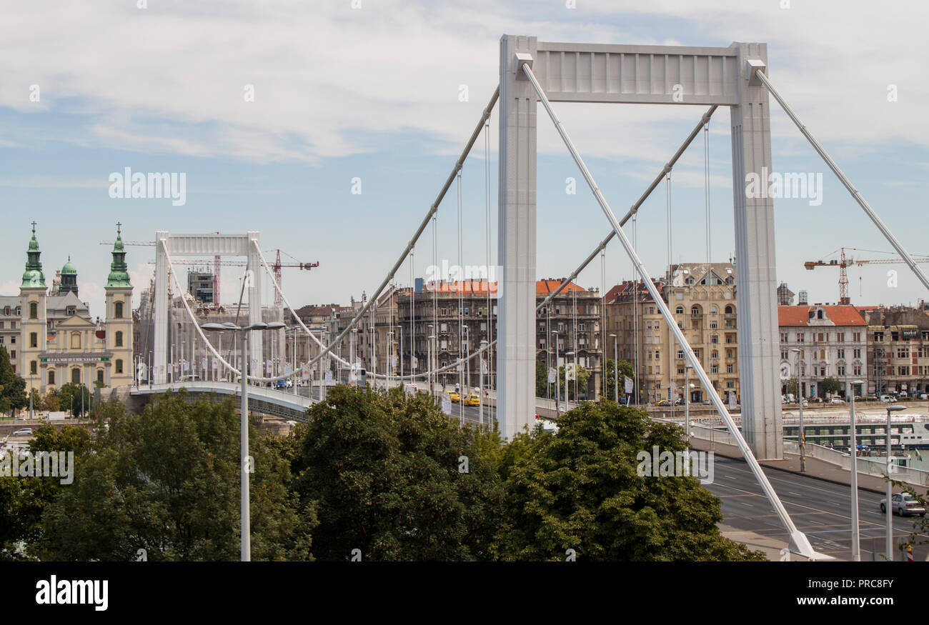 Vista la principale chiesa parrocchiale di Santa Maria Assunta e il ponte Elisabetta, il collegamento di Buda e Pest attraverso il Fiume Danubio a Budapest, in Ungheria, in Europa. Foto Stock