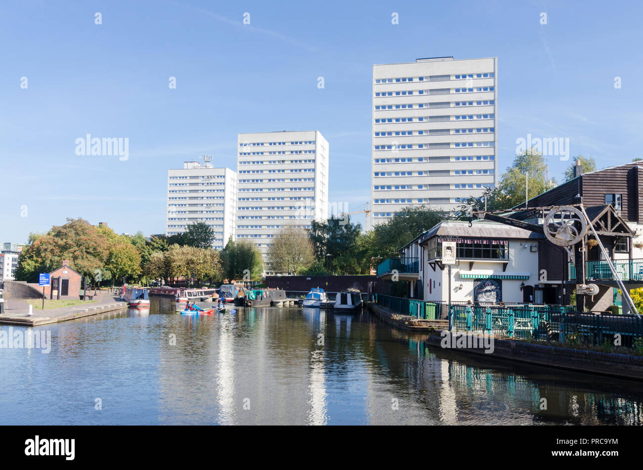 Elevato aumento di blocchi di ex consiglio appartamenti vicino al canale nel centro di Birmingham con l'enca e Firkin pub in primo piano Foto Stock