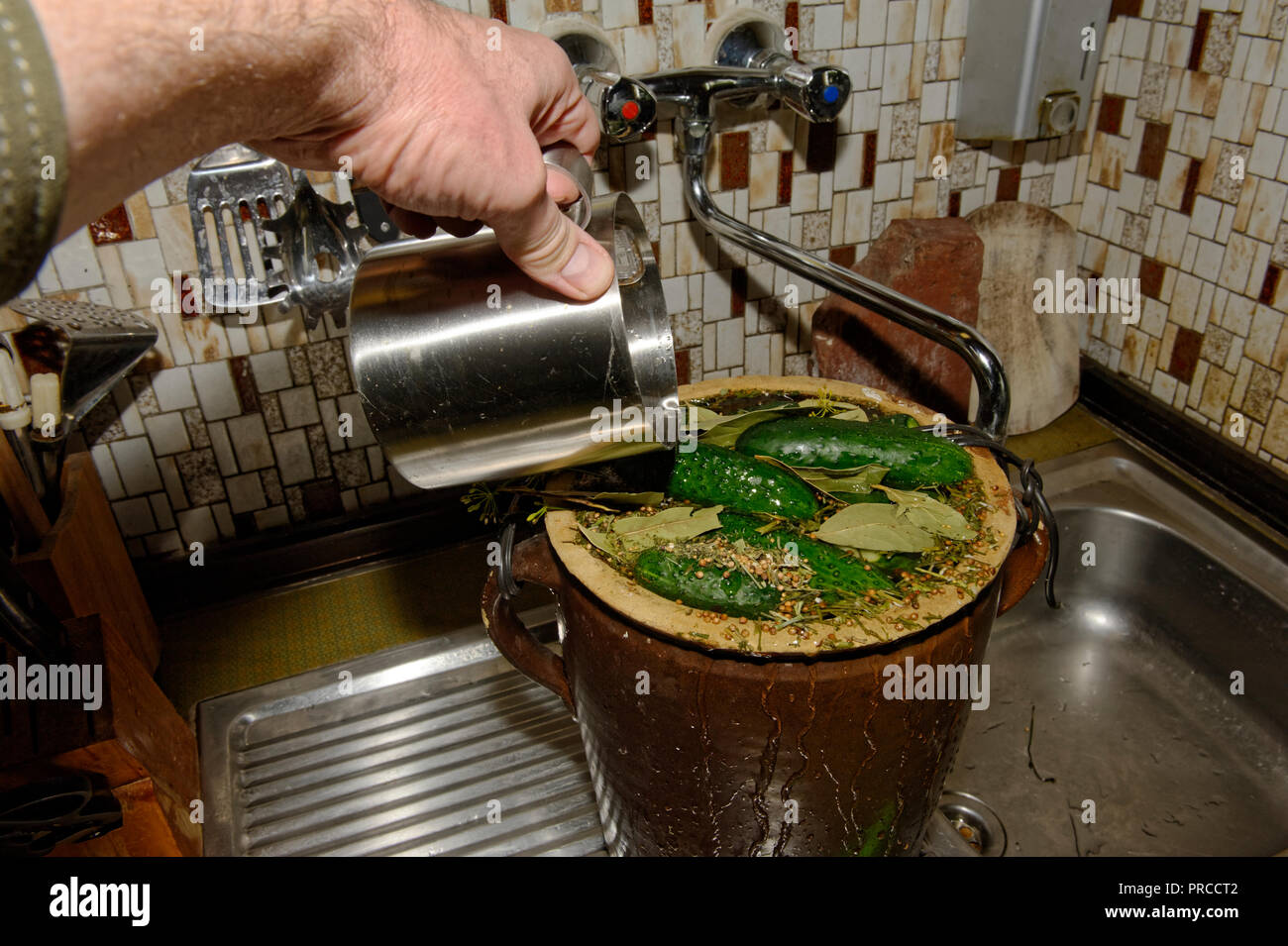 Verde sottaceto cetrioli in vasi di vetro sul bancone della cucina Foto Stock