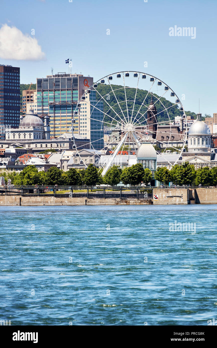 Paesaggio urbano del vecchio porto di Montreal, Quebec, Canada, sul fiume San Lorenzo e la ruota panoramica. Foto Stock