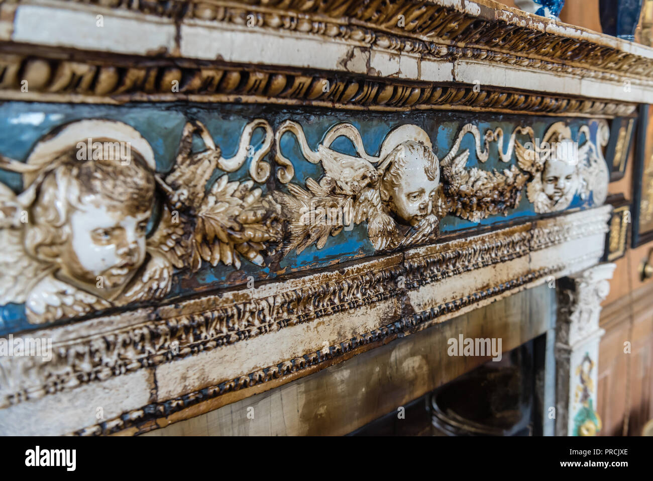 Il fumo colorate piastrelle in ceramica di un focolare attorno ad un molto vecchio camino di una casa nobiliare. Foto Stock