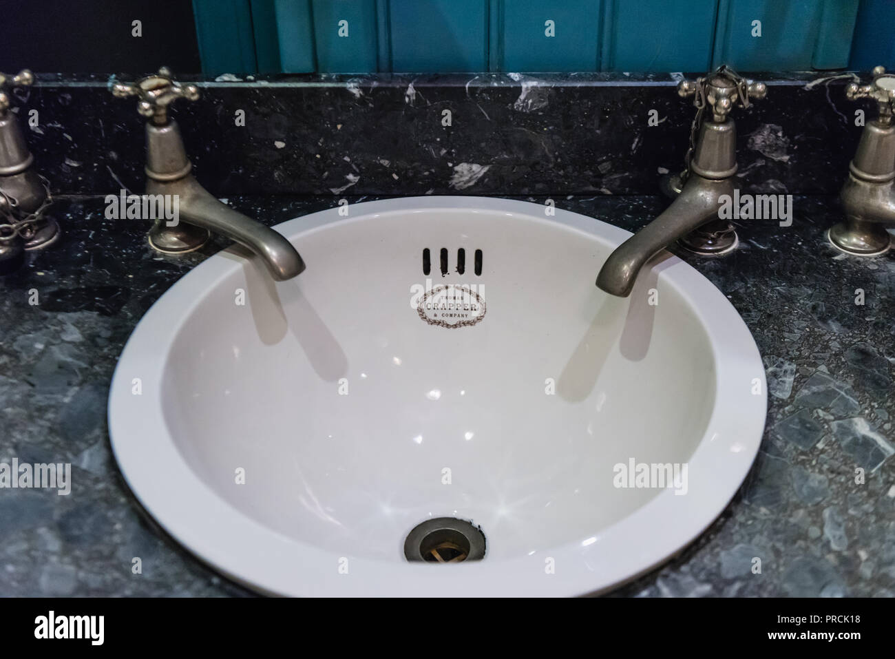 Logo su un vecchio lavandino del bagno e rubinetti realizzati da Thomas Crapper e azienda Foto Stock