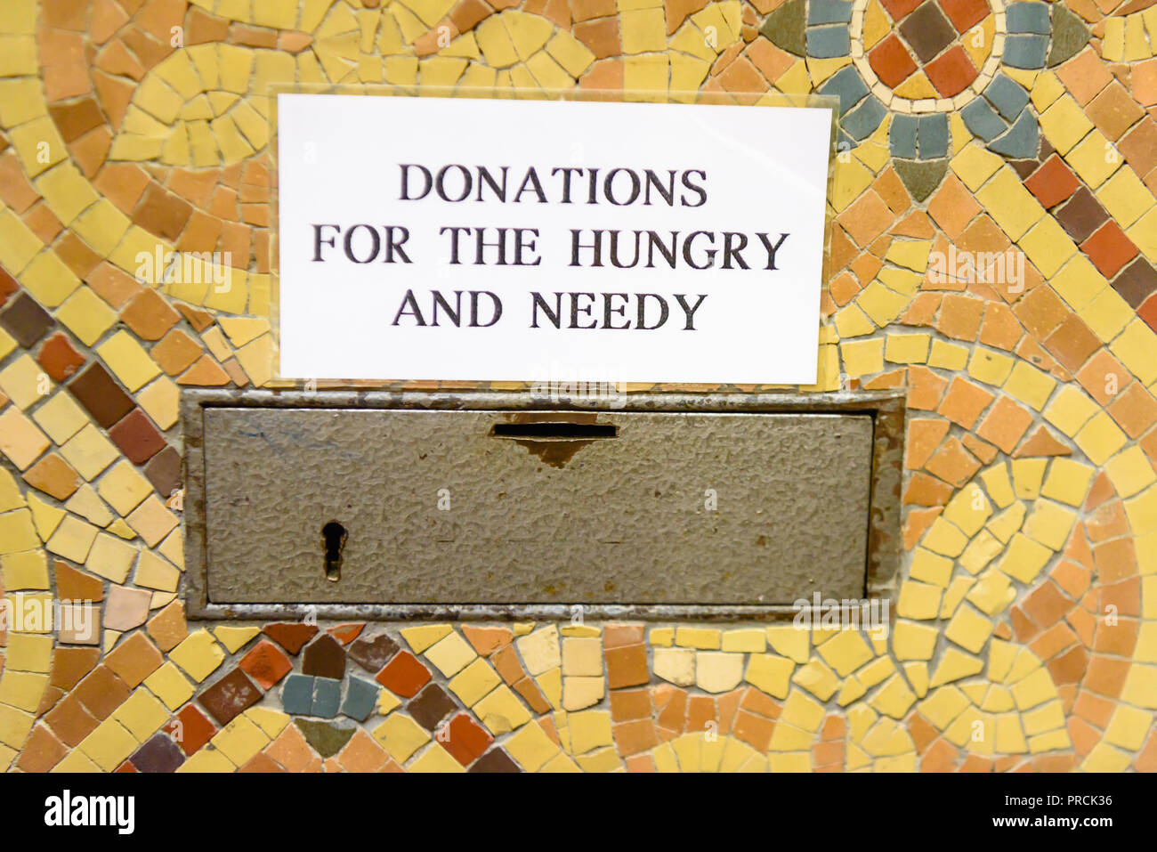 Cassetta di raccolta in una chiesa chiedendo donazioni per gli affamati e i bisognosi. Foto Stock