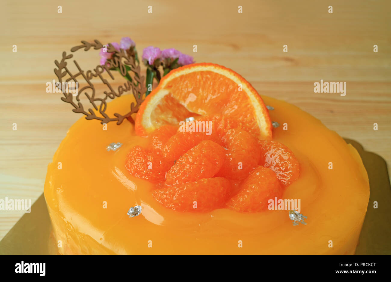Colori brillanti arancio mandarino torta di compleanno sul tavolo di legno Foto Stock