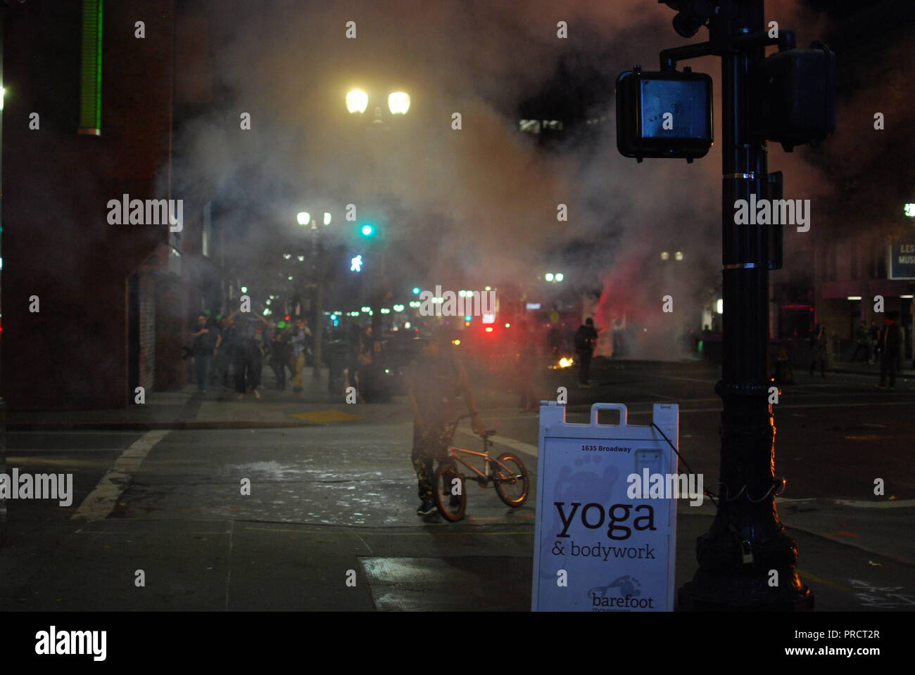 Una nuvola dopo una granata di fumo la distribuzione da parte di forze di polizia su Broadway in Oakland durante le proteste per l elezione del presidente Donald Trump su nov. 9, 2016. Foto Stock