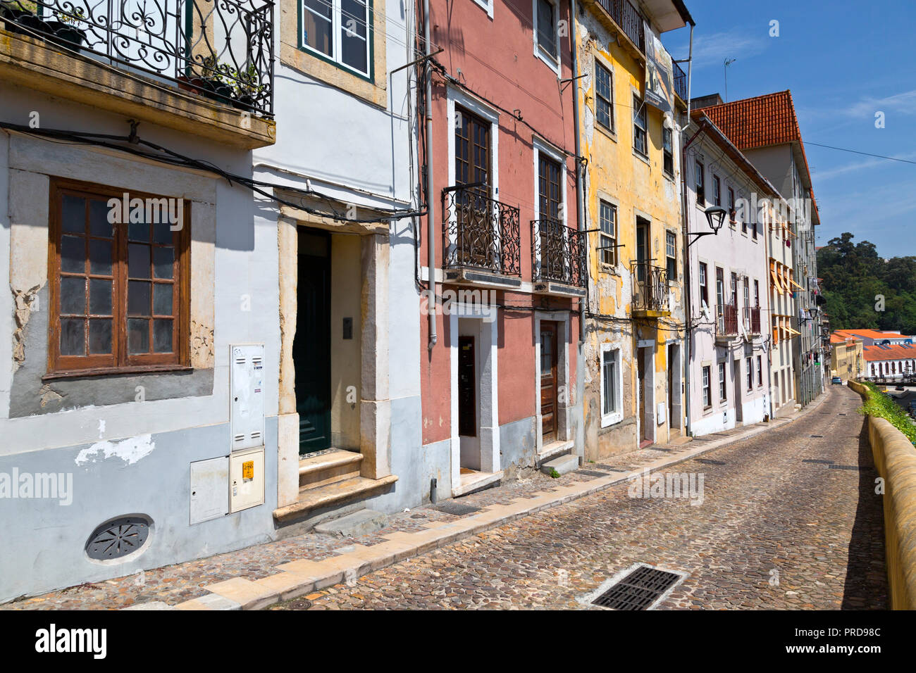 Fila di appartamenti con sbriciolamento facciata lungo una stretta strada di Coimbra, in Portogallo. Foto Stock