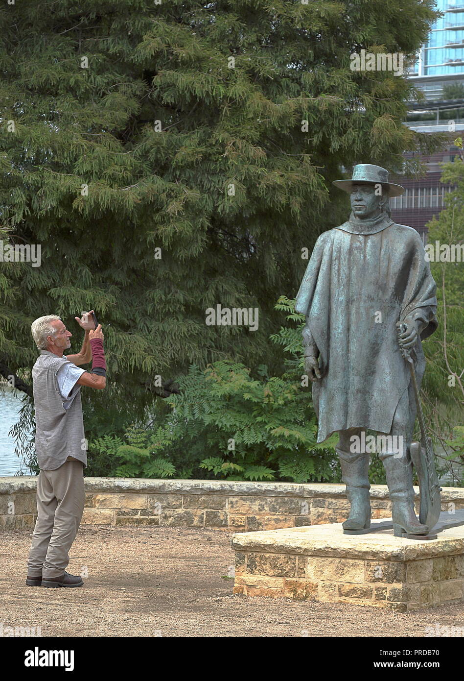 Austin, Texas - 23 Settembre 2018: un turista sta immagine di Stevie Ray Vaughan statua, lavoro da Ralph Helmick, di Austin in Texas Foto Stock