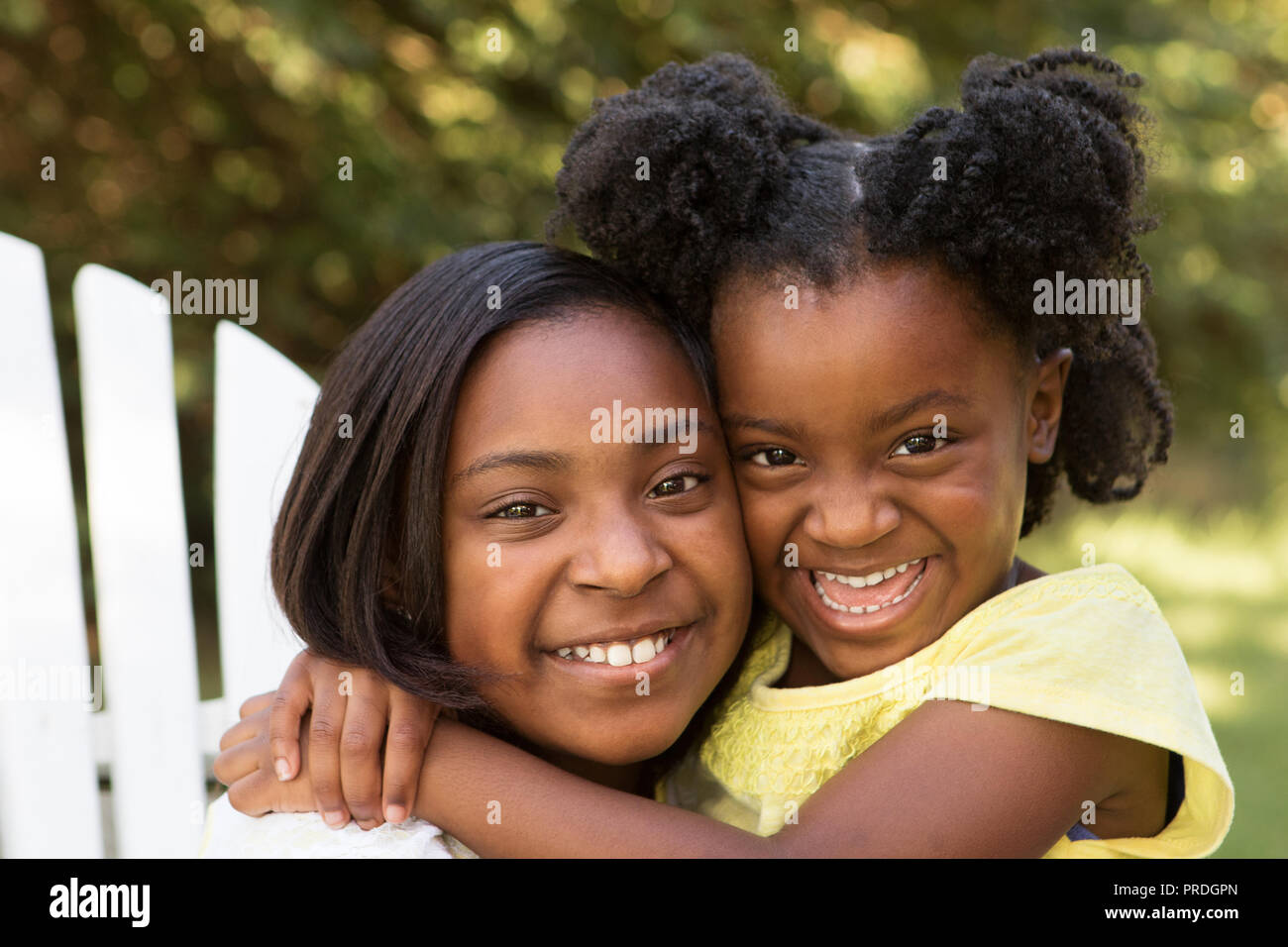Ritratto di due americano africano sorelle abbracciando all'esterno. Foto Stock