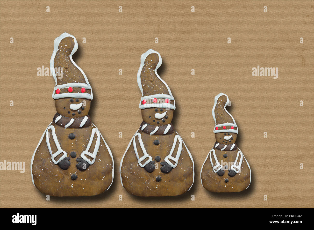 Tre gingerbread cookies, uomini isolati su sfondo marrone, close up, laici piatta Foto Stock