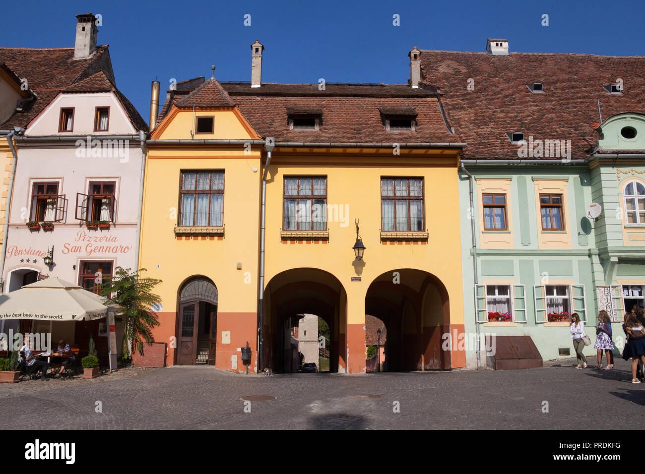 Edifici e ristoranti nella piazza della città vecchia di Sighisoara, Romania Foto Stock