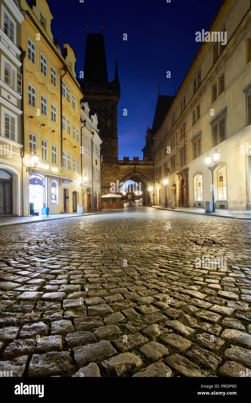 Via medievale che conduce verso il Ponte di Carlo torre su una notte piovosa a Praga, Repubblica Ceca Foto Stock