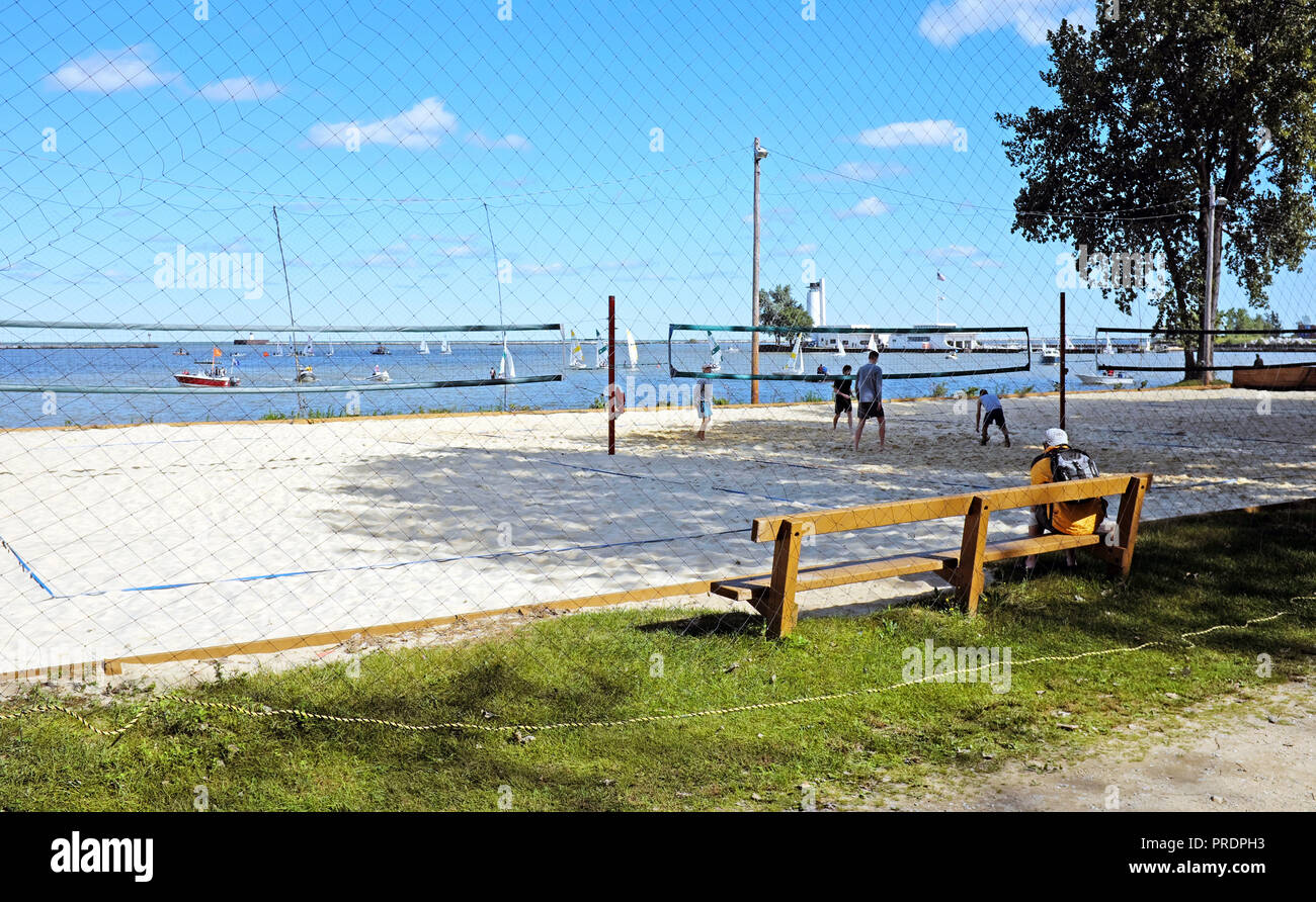 Con barche a vela in background, un inizio di caduta pallavolo gioco accade in Wendy Park sulle rive del Lago Erie in Cleveland, Ohio, USA. Foto Stock
