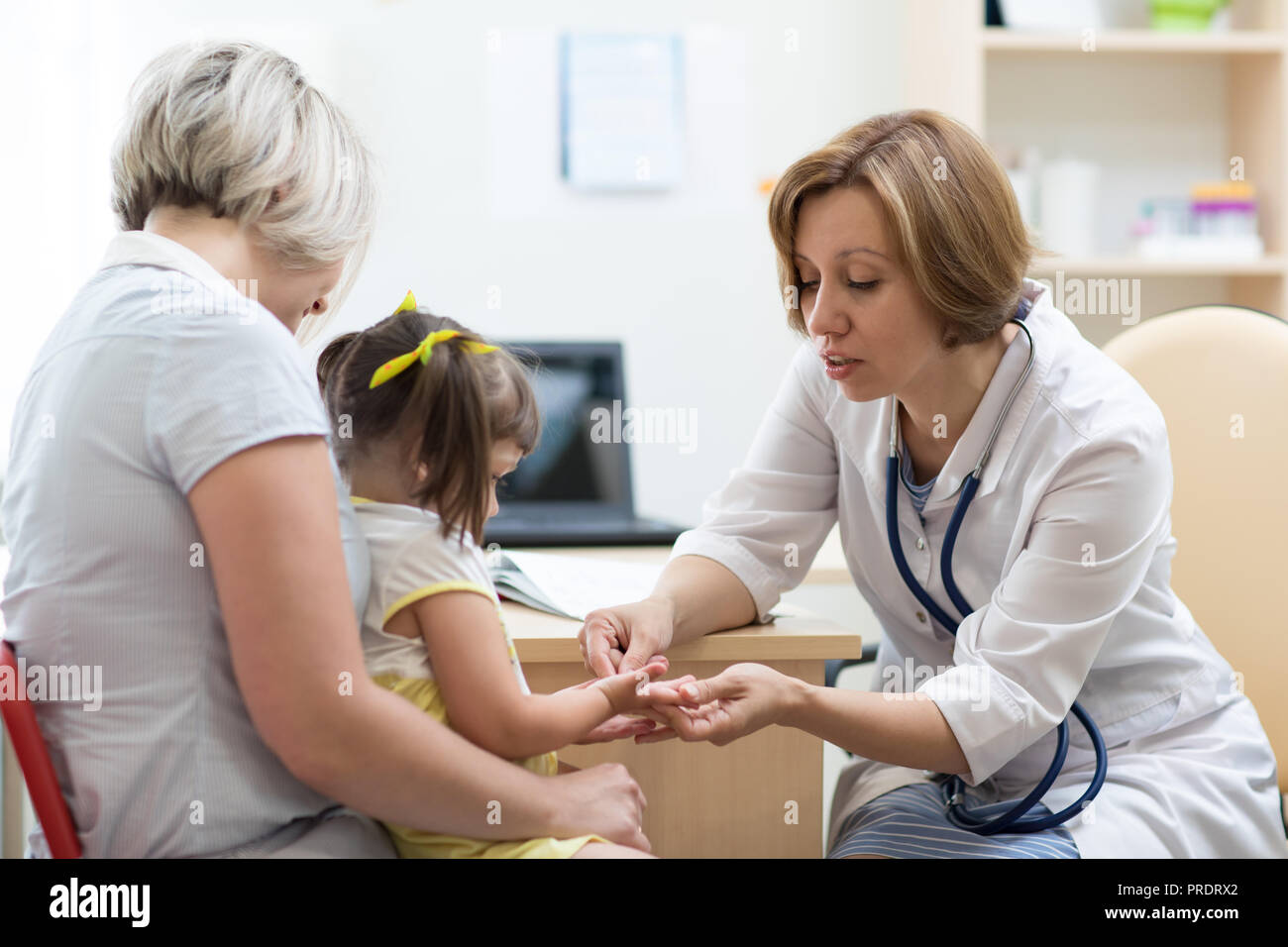 Bambina con la sua madre ad un medico per la consultazione Foto Stock