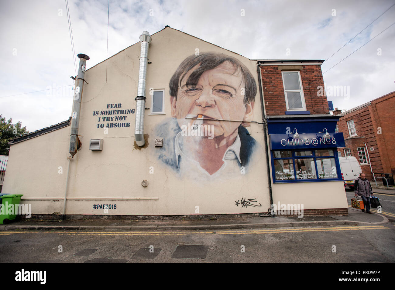 Prestwich, Regno Unito. 1 ottobre 2018. Akse p19, artista di graffiti, completa il suo ritratto del frontman "The Fall" Mark E.Smith, sul lato di un negozio di chip a Manchester. Il cantante 'The Fall', morto nel gennaio 2018, viene commemorato nella sua città natale di Prestwich, Greater Manchester per un Arts Festival. Credit: Howard Harrison/Alamy Live News Foto Stock