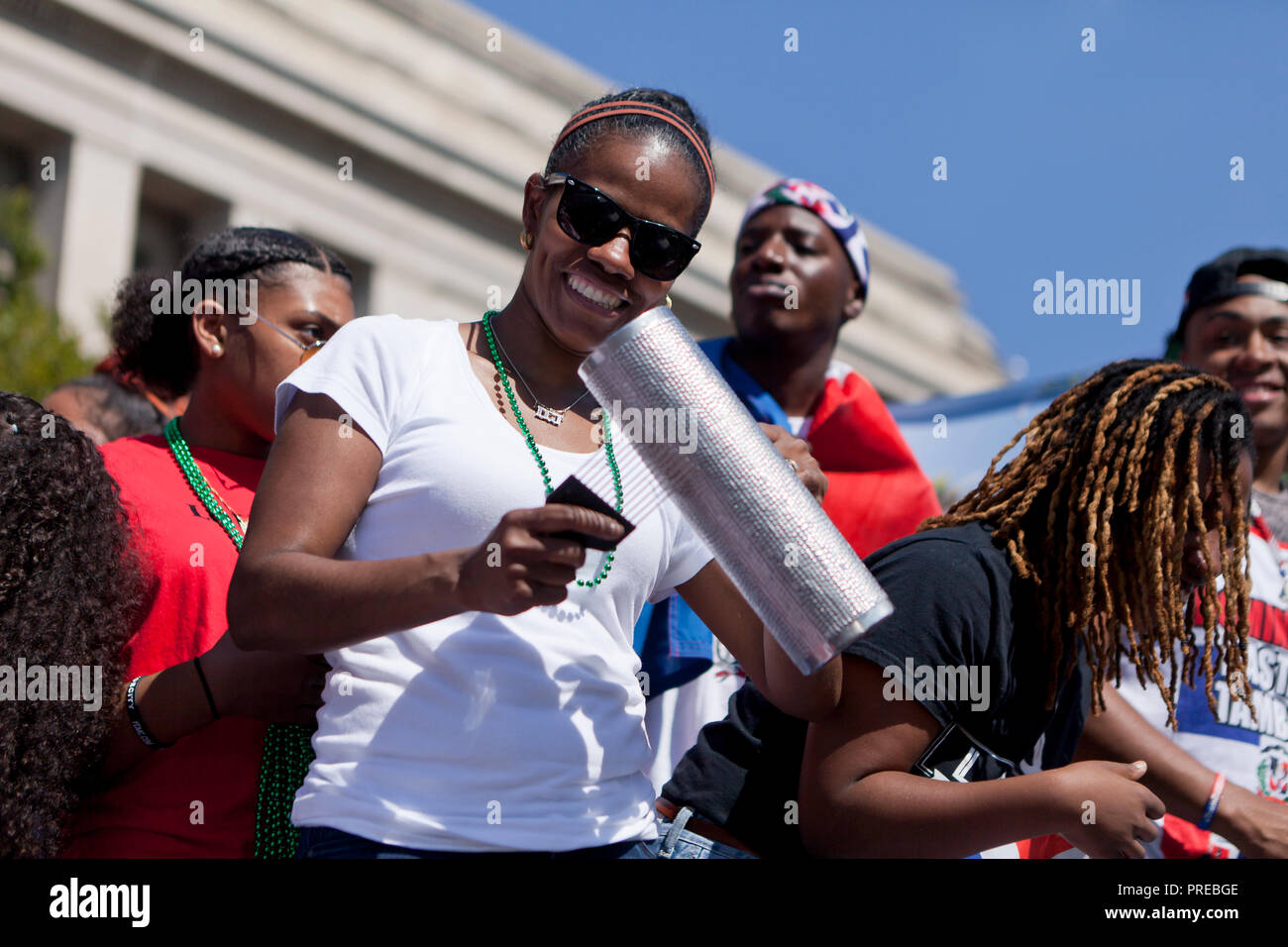 Donna afro-cubane giocando un metallo guiro durante un festival Latinoamericano - USA Foto Stock