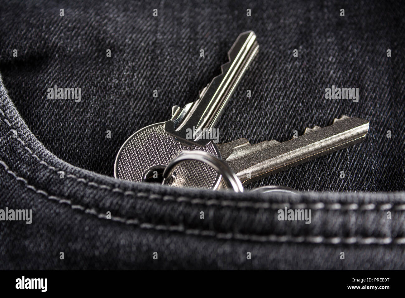 Chiavi di argento si trovano nella parte anteriore della tasca dei jeans neri. Close-up. Foto Stock