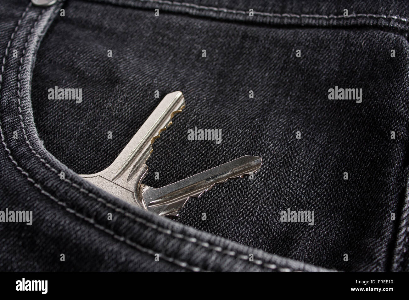 Chiavi di argento si trovano nella parte anteriore della tasca dei jeans neri Foto Stock