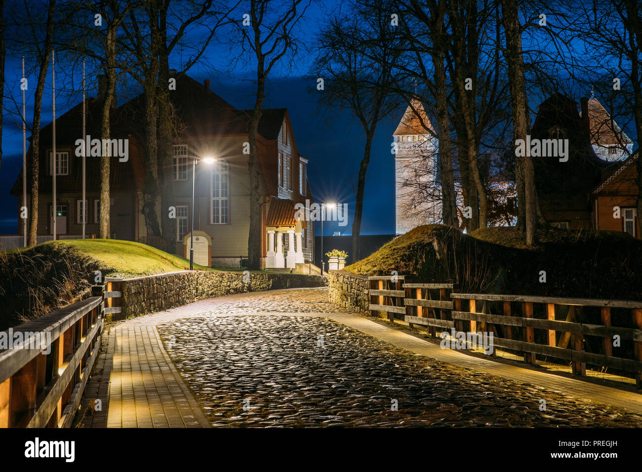 Kuressaare, isola di Saaremaa, Estonia. Cabblestone Road vicino al castello vescovile di illuminazione notturna. Foto Stock