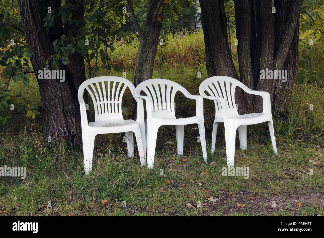 Tre sedie in plastica bianca all'aperto Foto Stock