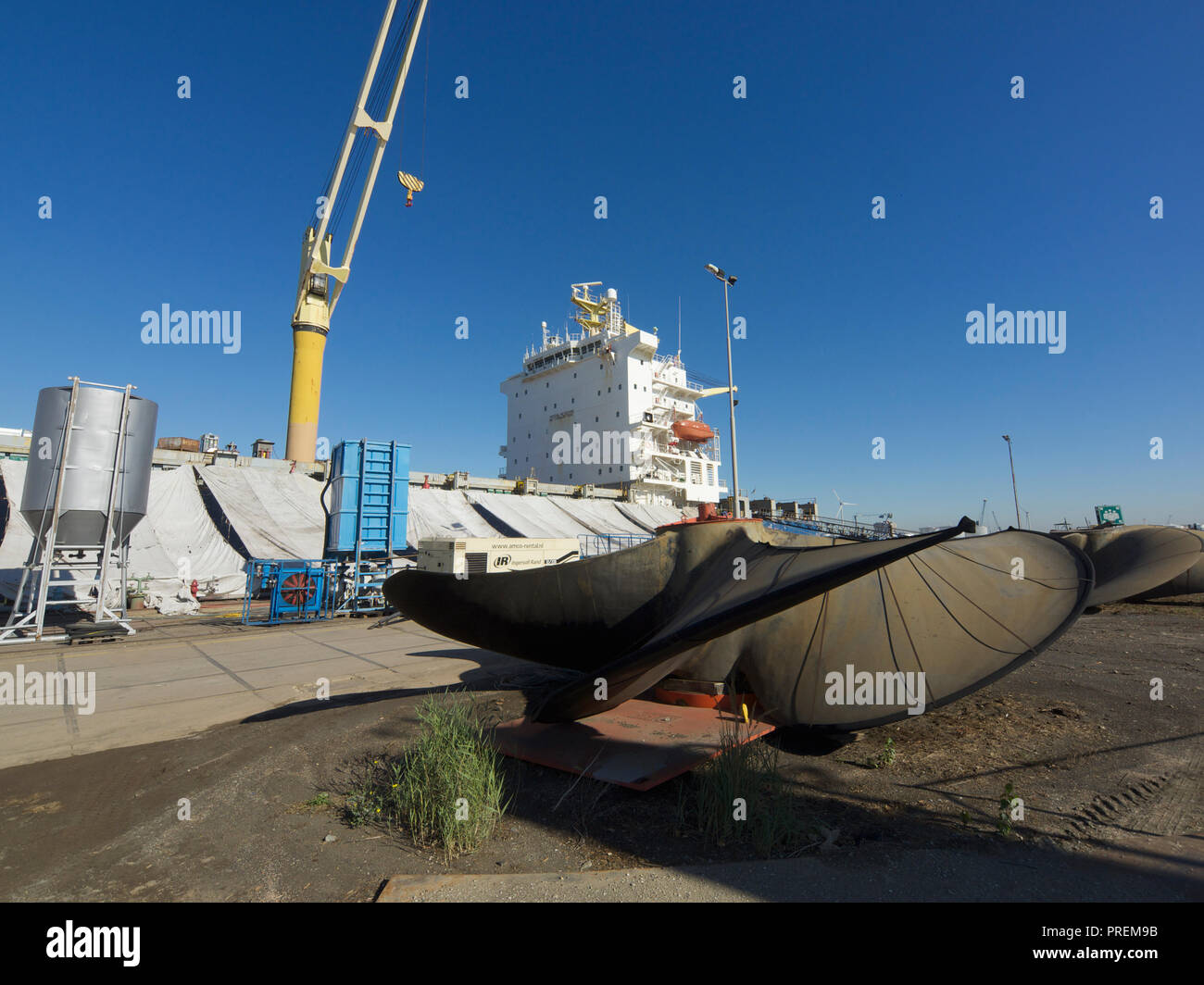 Nave da carico in bacino di carenaggio per la manutenzione con elica di grandi dimensioni in primo piano, il porto di Anversa, Belgio Foto Stock