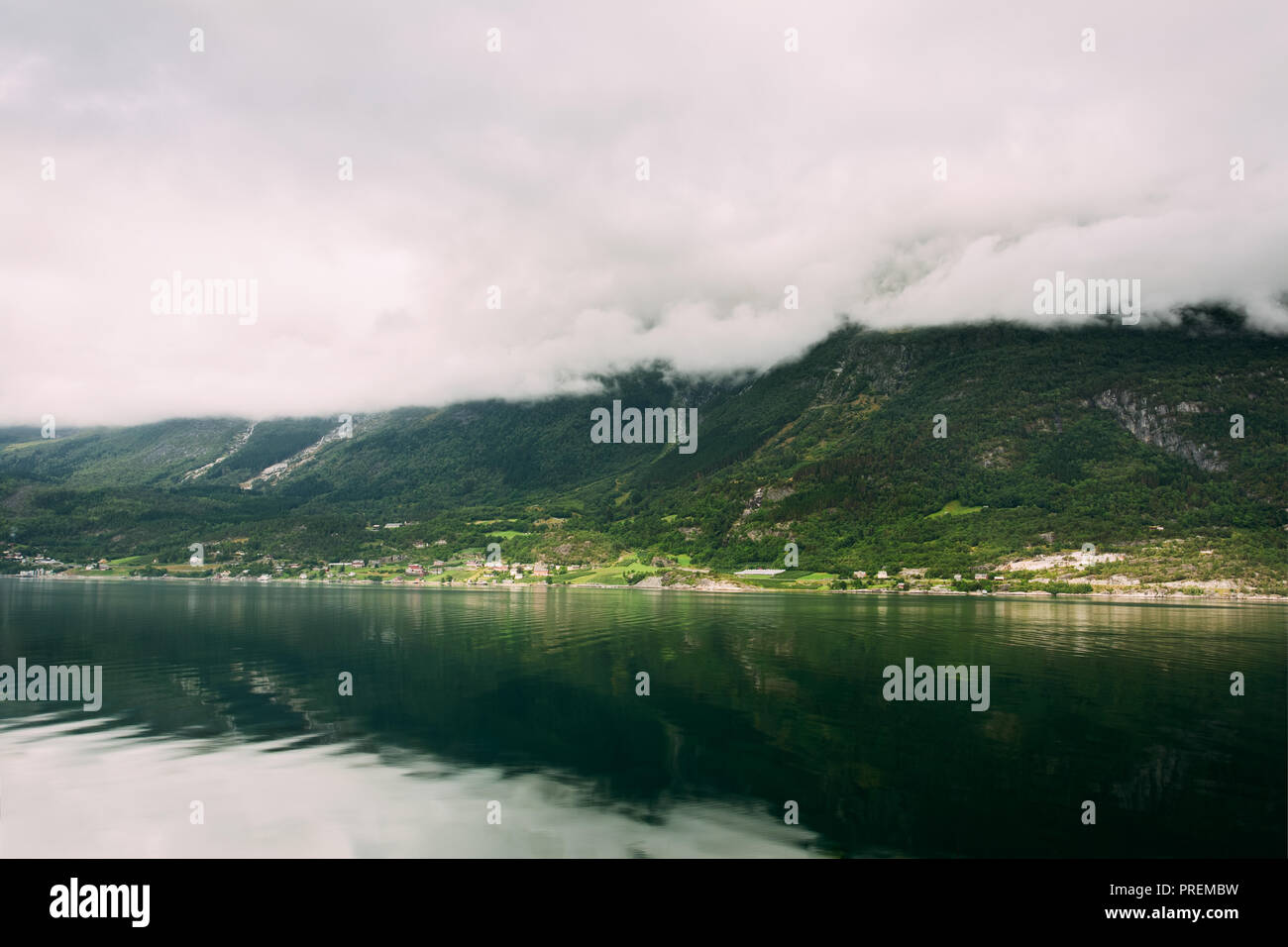 Hardangerfjord, Norvegia. Paesaggio estivo con Scandinavian villaggio sulle rive del Hardangerfjord. Hardangerfjord è il quarto fiordo più lungo al mondo Foto Stock