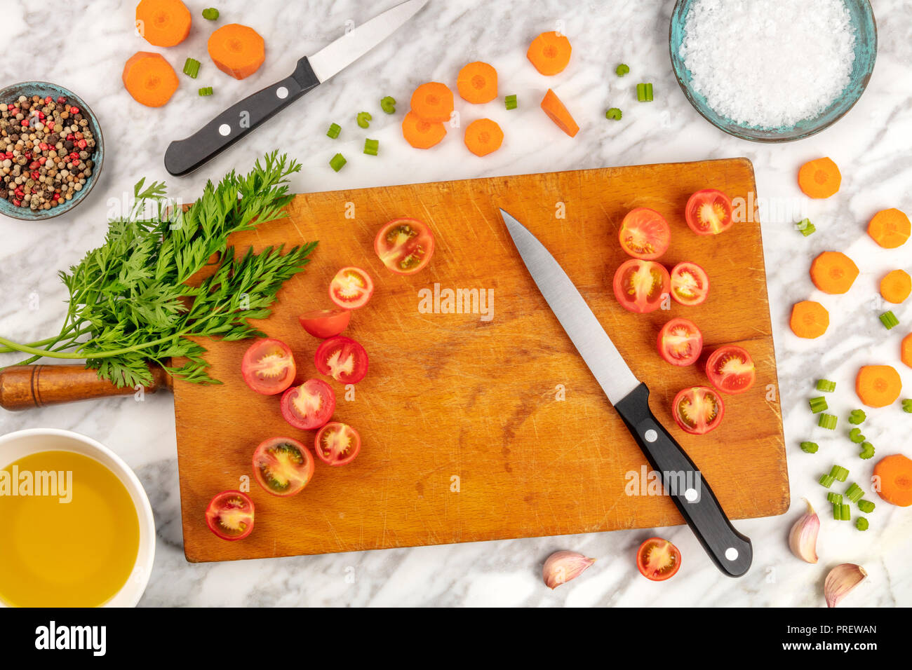 Tempo di preparazione o di mise en place. Un overhead foto professionali di un Coltello per cuoco, ripresa dall'alto su un tagliere con un trito di verdure e spezie, sul marmo di un piano di cottura con spazio di copia Foto Stock