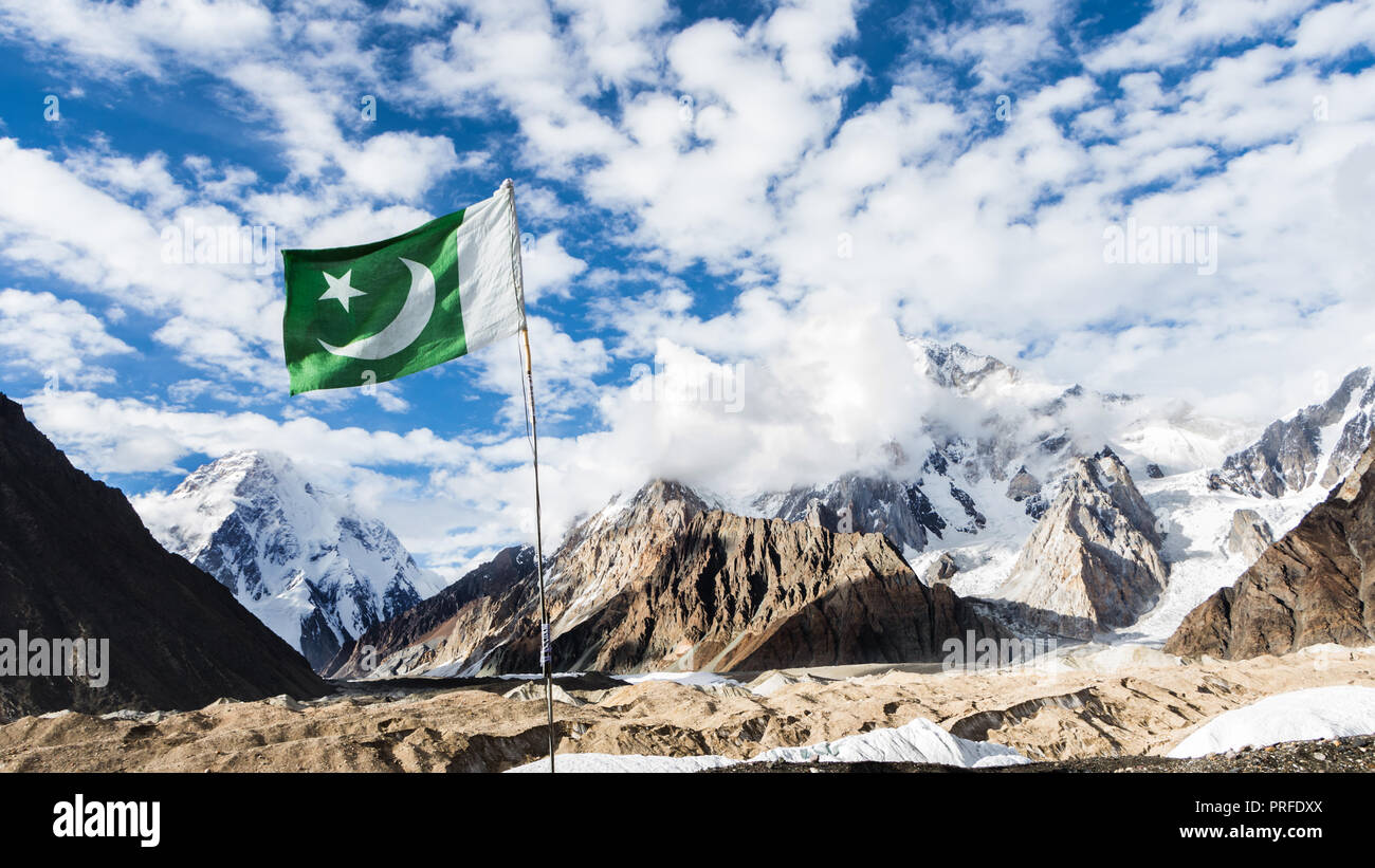 Il Pakistan bandiera in concordia sul ghiacciaio del Baltoro, con K2 e Broad Peak montagne sullo sfondo, il Karakoram, Pakistan Foto Stock