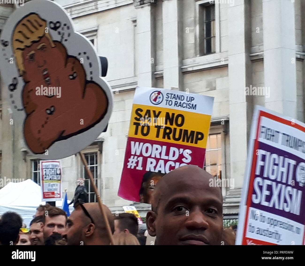 Londra, UK, 13 luglio 2018. 100.000 persone protestano contro la visita del Presidente statunitense Donald Trump. I manifestanti si raccolgono in Trafalgar Square. Cartelli possono essere visto che raffigurano Trump come un poo circondato da mosche e facendo riferimento al razzismo e sessismo. Foto Stock