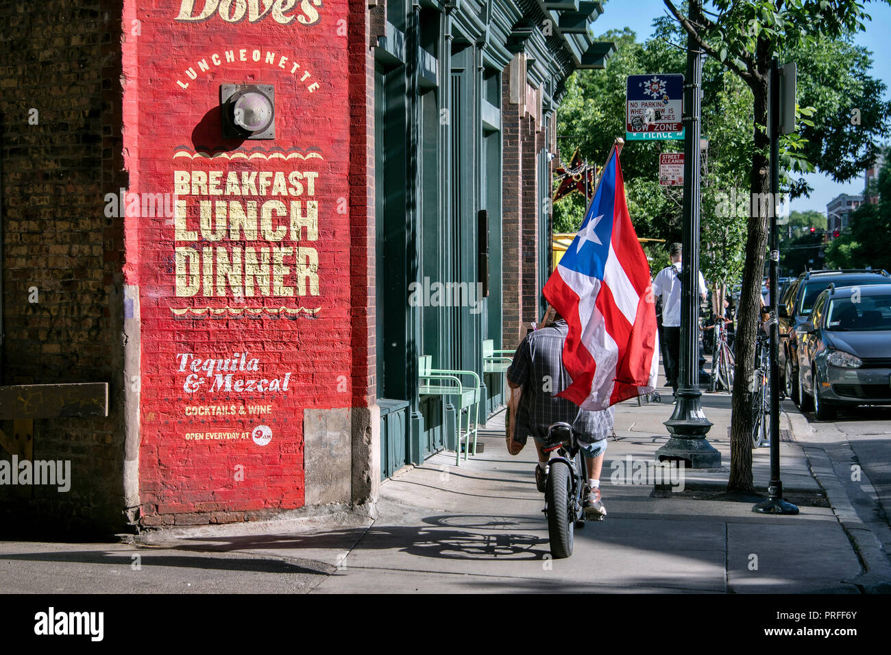 Ciclista con il Puerto Rican bandiera accanto alla colomba's Luncheonette, ristorante, Nord Damen Avenue, Wicker Park, Chicago, Illinois, Stati Uniti d'America Foto Stock