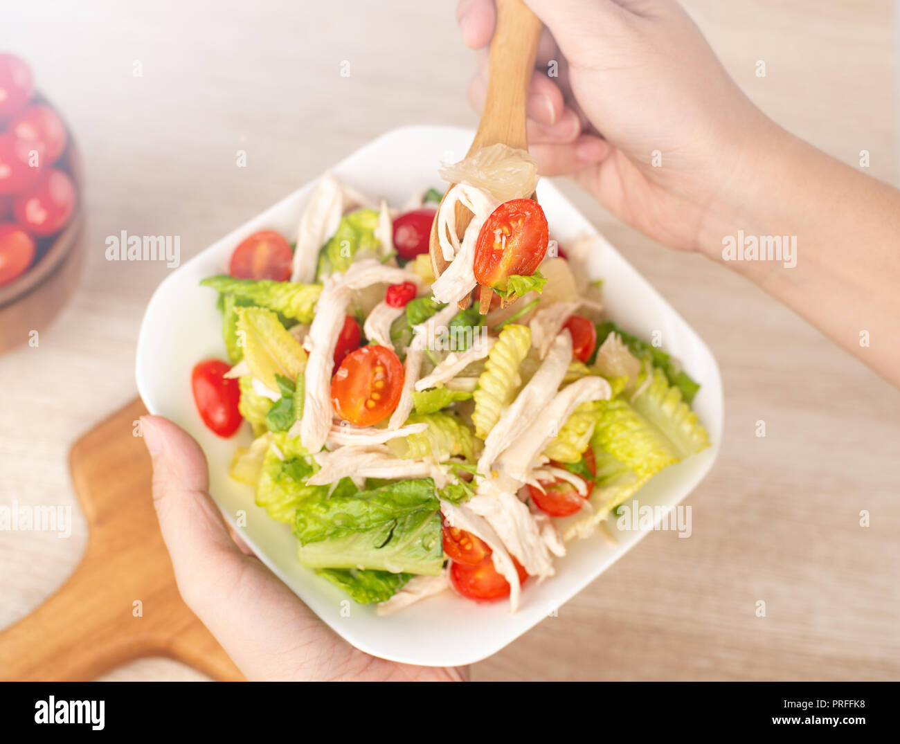 Fresca e deliziosa casa insalata di pollo con pomodori e i pomeli in background in legno, concetto di sano e la dieta, vista dall'alto, spazio di copia Foto Stock