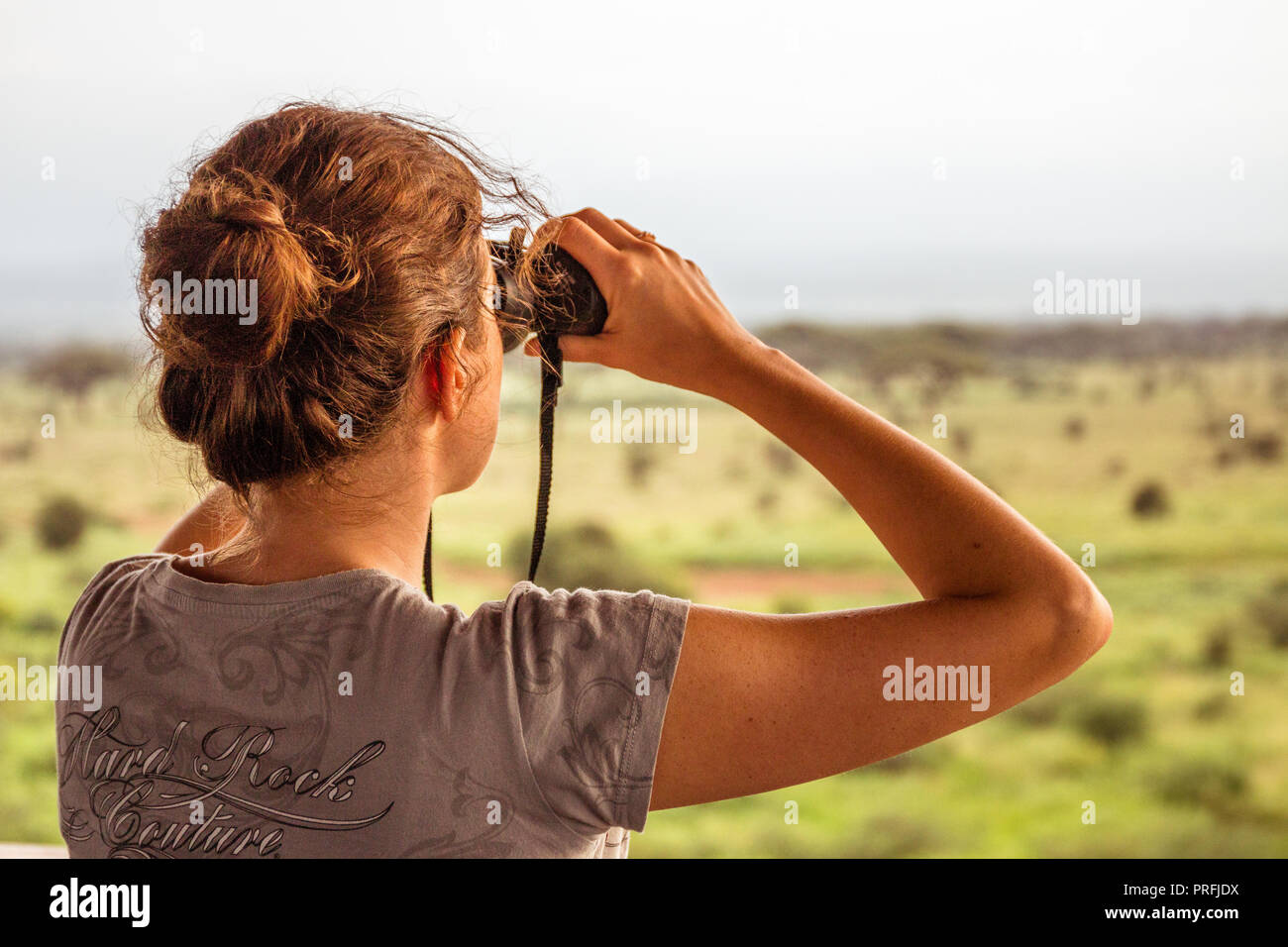 Ragazza utilizzando boniculars al safari in Africa Foto Stock