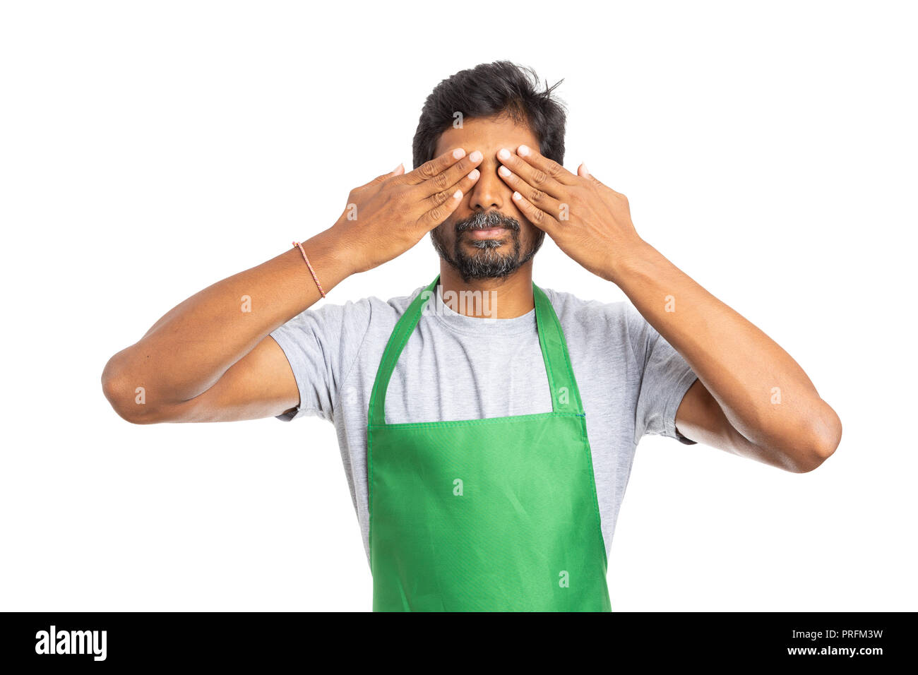 Indian supermercato o ipermercato dipendente che copre gli occhi con le mani come gli occhi bendati concetto isolato su bianco di sfondo per studio Foto Stock
