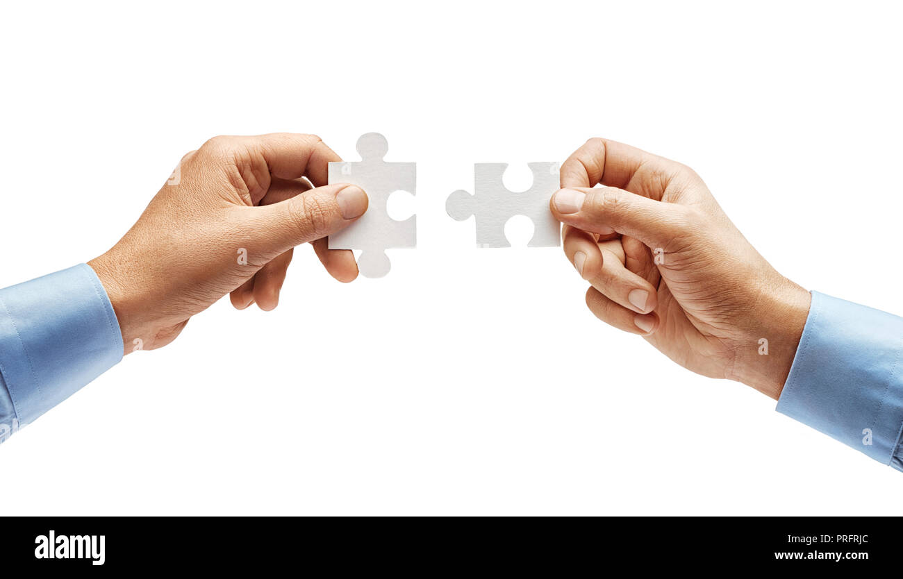 Due mani dell'uomo in camicia il collegamento di Jigsaw Puzzle isolati su sfondo bianco. Close up. Alta risoluzione prodotto Foto Stock