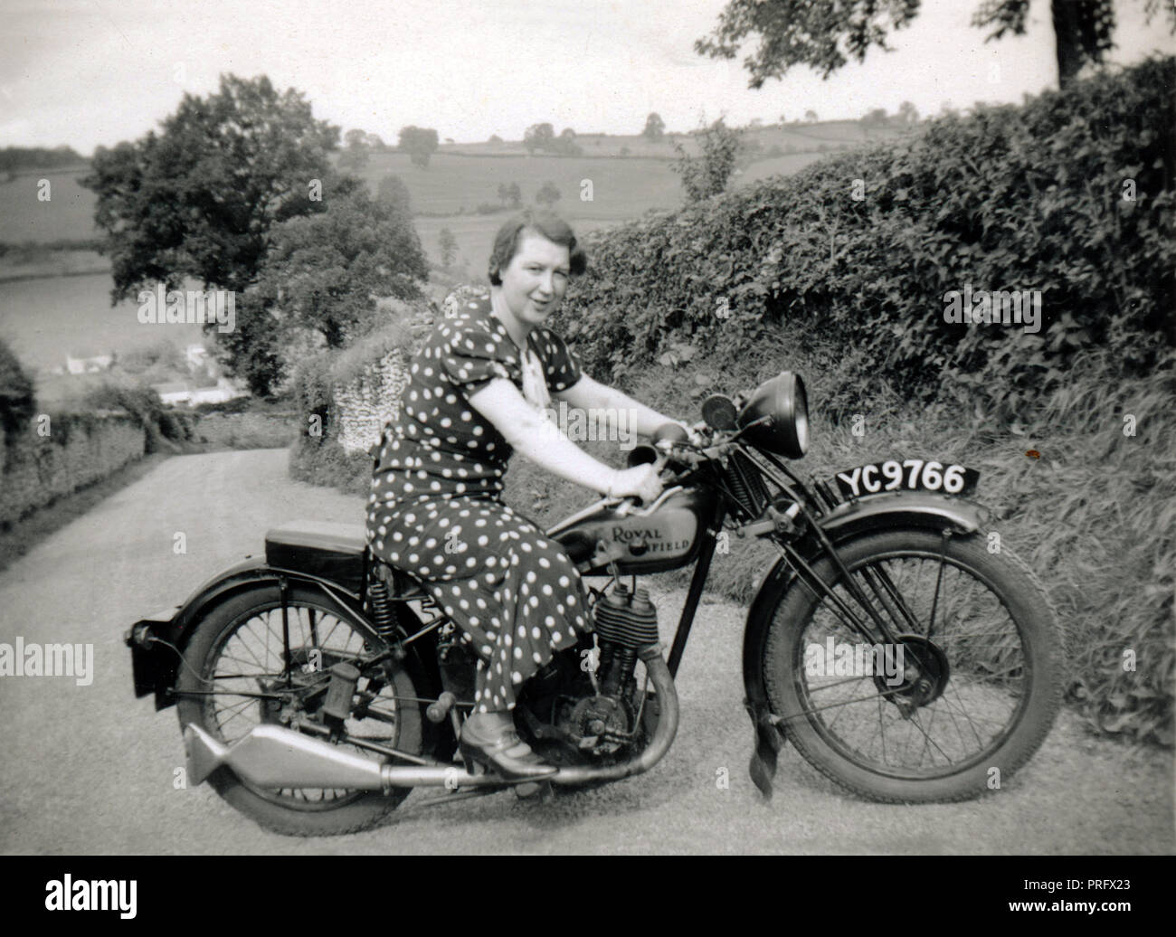 Signora su 1929 Royal Enfield 350cc valvola lato motociclo in un vicolo del paese circa 1930 Foto Stock