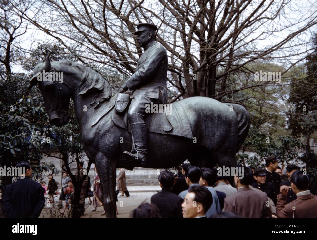 La folla di persone raccolte intorno a un soldato su una statua equestre in Giappone, 1965. () Foto Stock