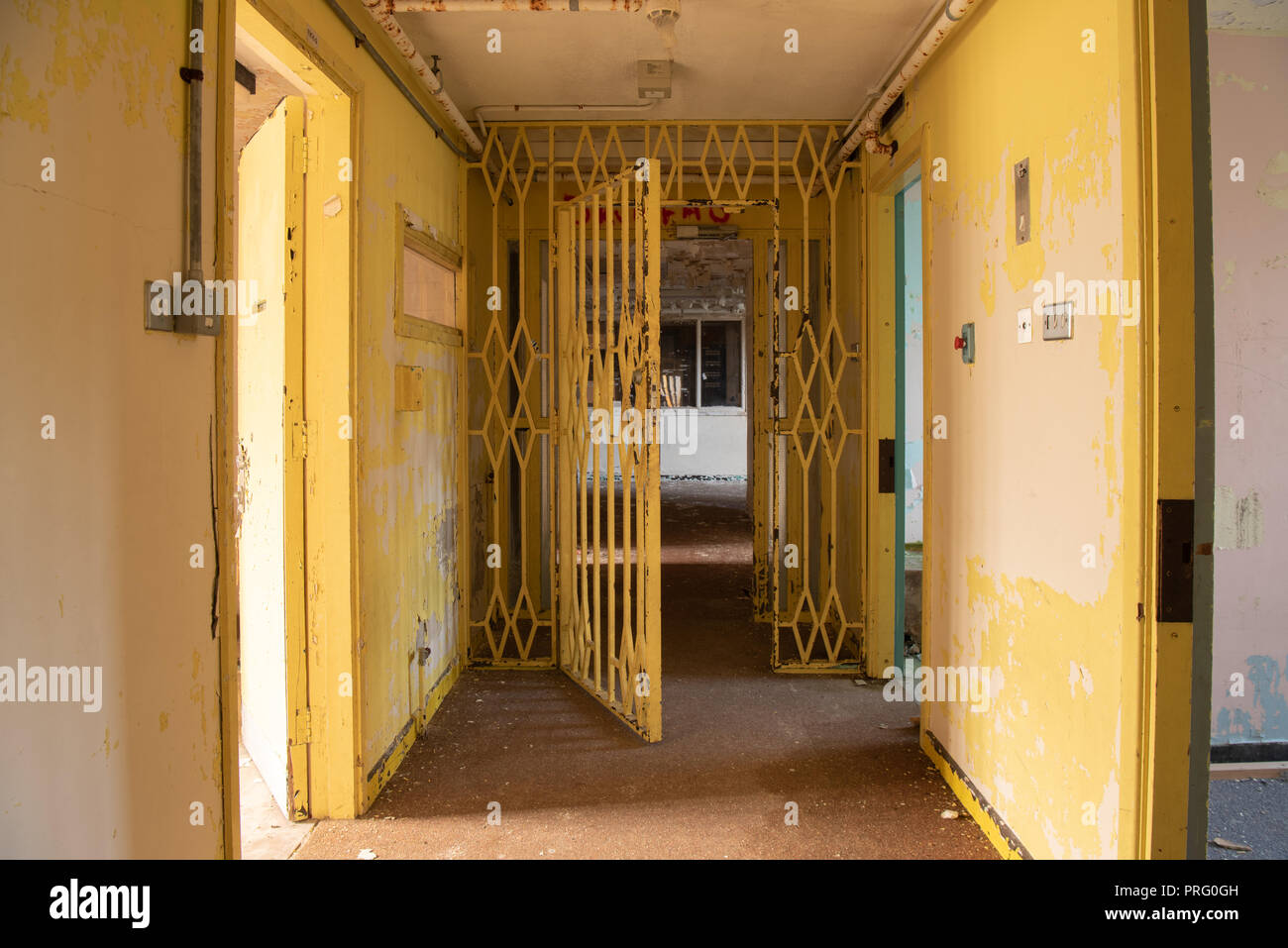 Porta in acciaio alla fine di un corridoio ala di un carcere abbandonato. Foto Stock