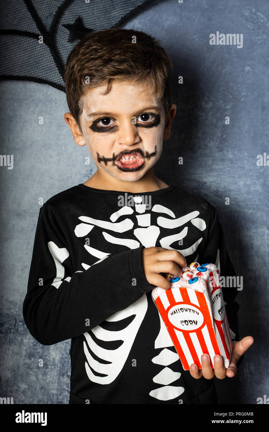 Bambino in un costume di scheletro di mangiare fake occhi su Halloween Foto  stock - Alamy