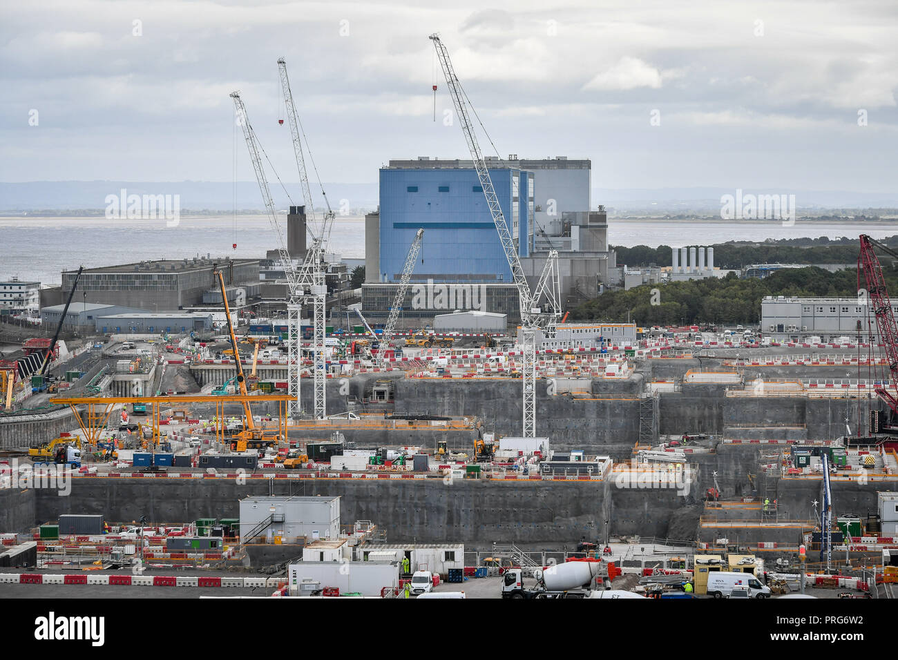 Hinkley Point di una centrale nucleare si siede dietro il nuovo lavoro di costruzione in corso al EDF Energy Hinkley Point C di una centrale nucleare nel Somerset. Foto Stock