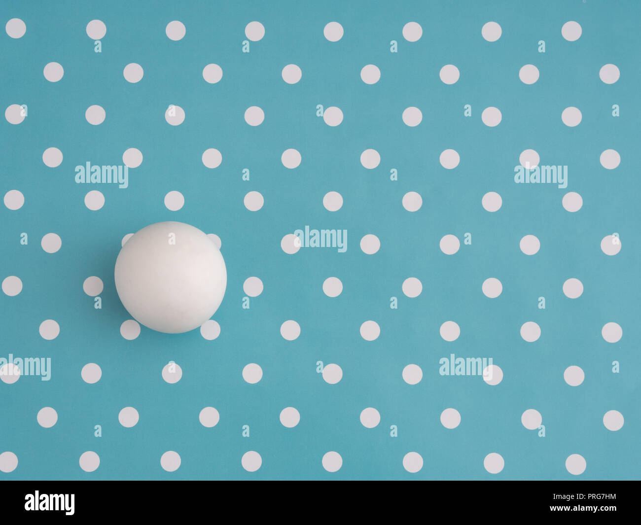 Bianco grande palla di marmo tra i piccoli punti sul turchese. Diverso e univoco o semplicemente tentando di adattare, montare a. Nascondere in Plain Sight, concetto. Foto Stock