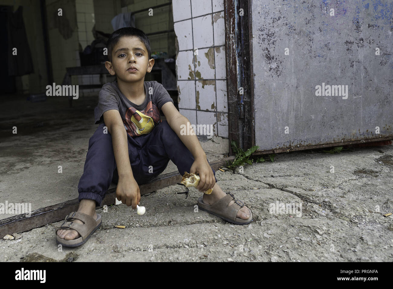 Velika Kladusa, in Bosnia ed Erzegovina. 23 Mar, 2018. Un ragazzo avendo visto situati holding qualcosa da mangiare al campo profughi.Refugee Camp di Velika Kladusa, Bosnia sul confine croato. I rifugiati qui tentare di entrare in Europa attraverso la Croazia ed è noto come il gioco; dove si cammina per 2 o 3 settimane nel tentativo di raggiungere l'Italia dove essi si applicherà per il riconoscimento dello status di rifugiato. Credito: Enzo Tomasiello SOPA/images/ZUMA filo/Alamy Live News Foto Stock