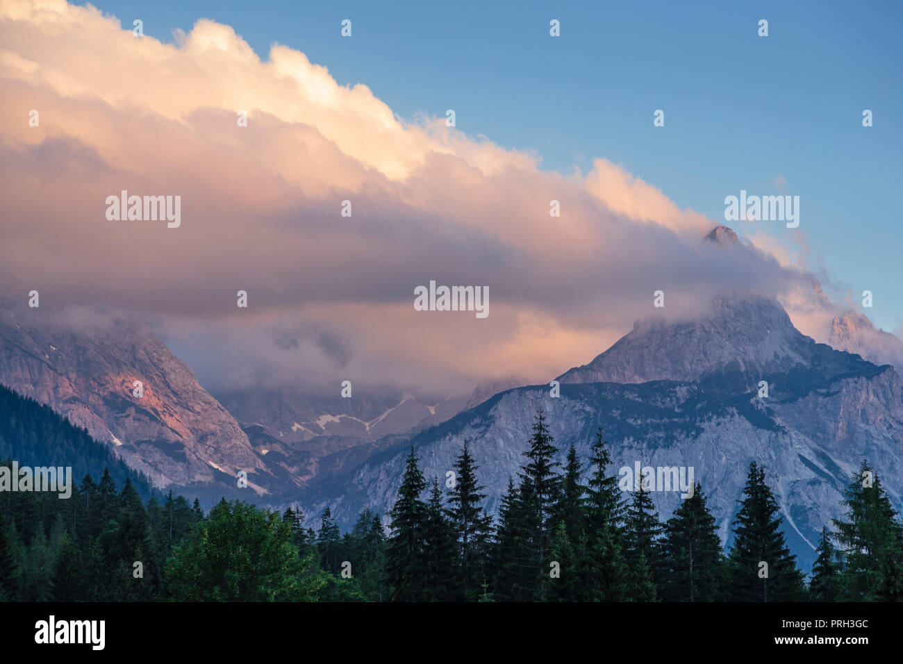 Nuvole attorno alla vetta del Monte Sonnenspitze renderlo simile è sul fuoco - Gamma di Wetterstein, Ehrwald, Tirolo, Austria Foto Stock