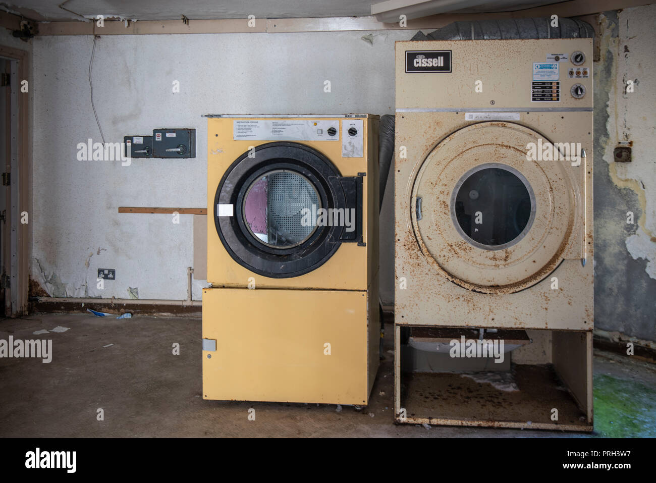 Industrial asciugatrice e lavatrice in un edificio abbandonato. Foto Stock
