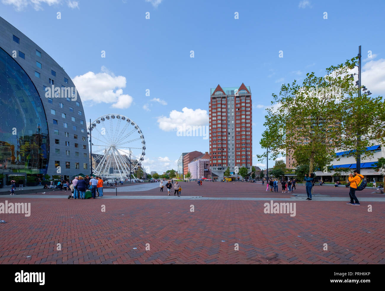 Grande piazza con gruppi di persone di fronte al famoso mercato hall di Rotterdam, Paesi Bassi. Accanto alla costruzione di una ruota panoramica Ferris. Foto Stock
